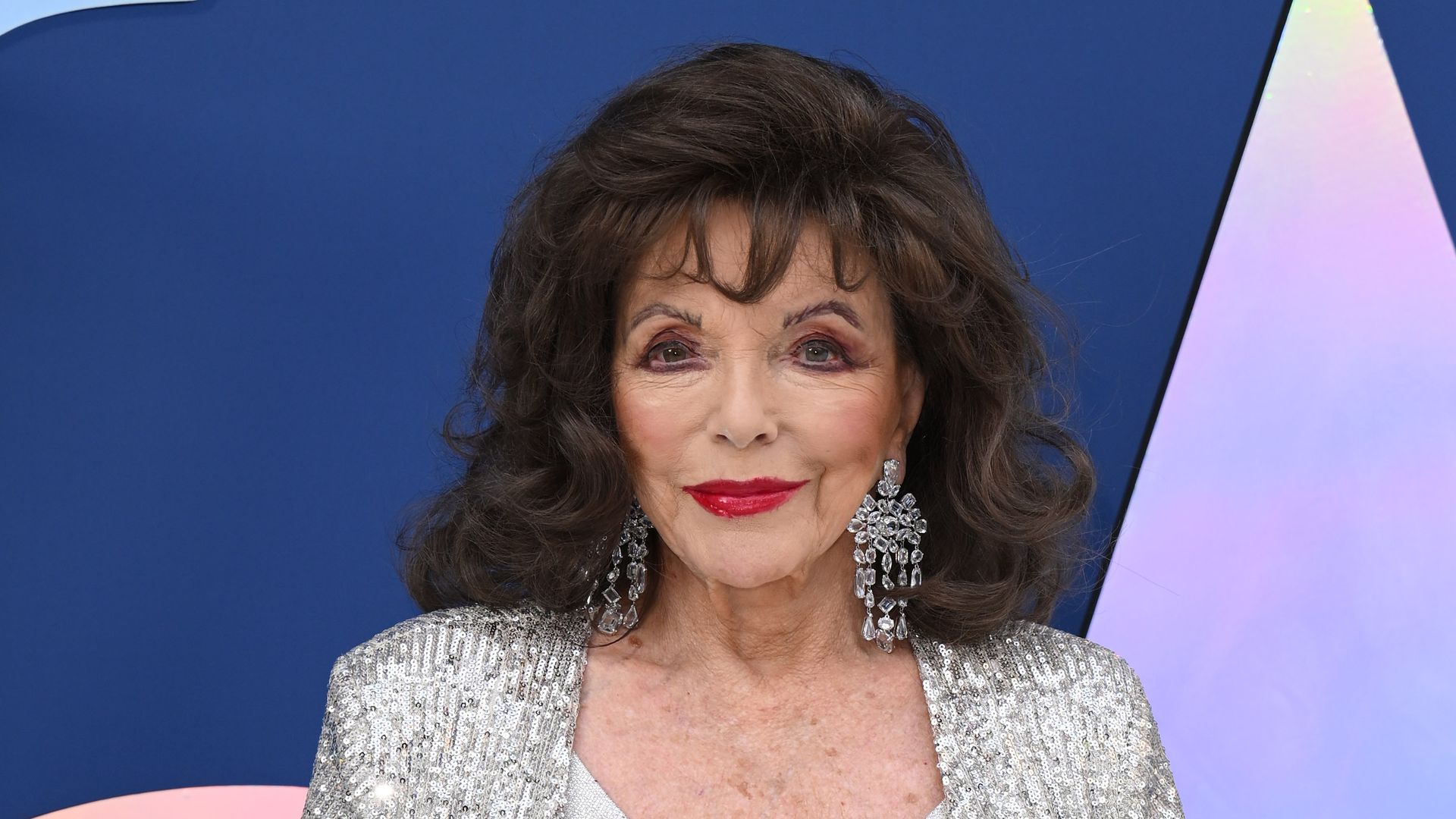 Joan Collins in silver gown with jacket