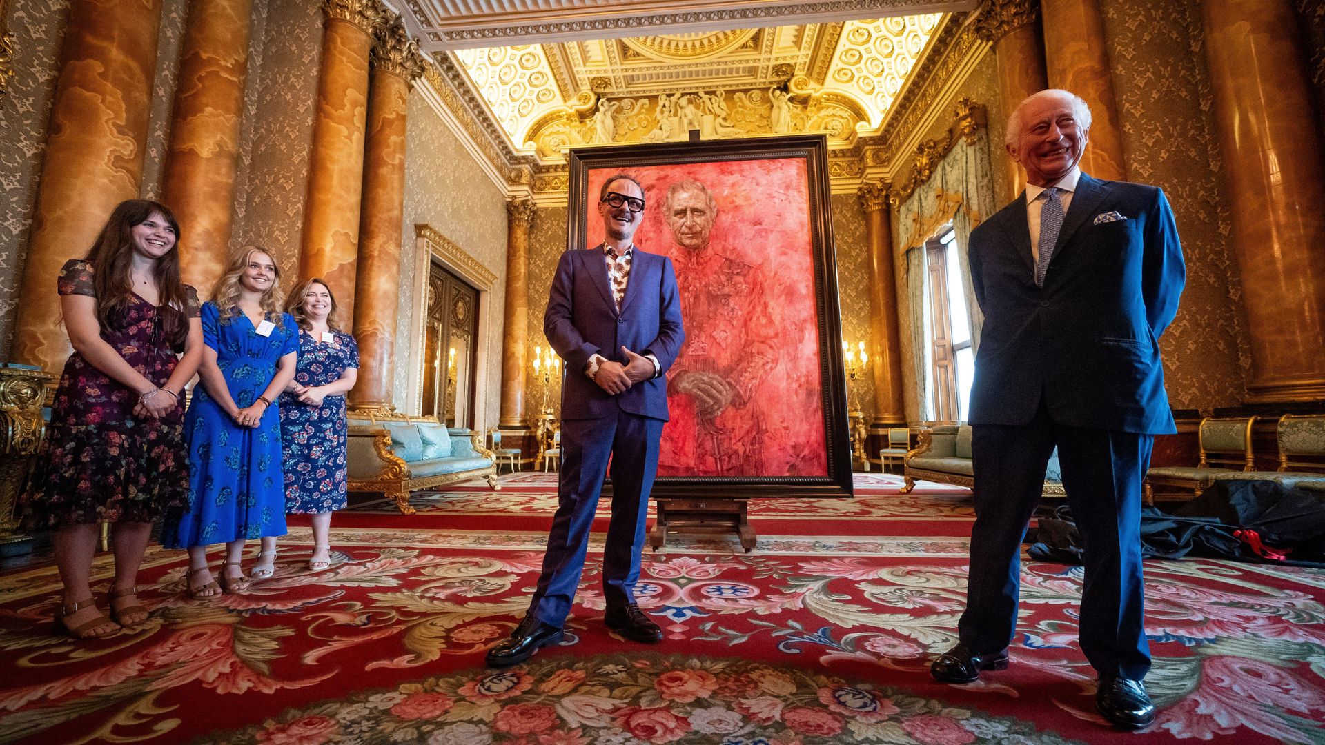 King Charles reacts as he unveils his first official portrait since coronation