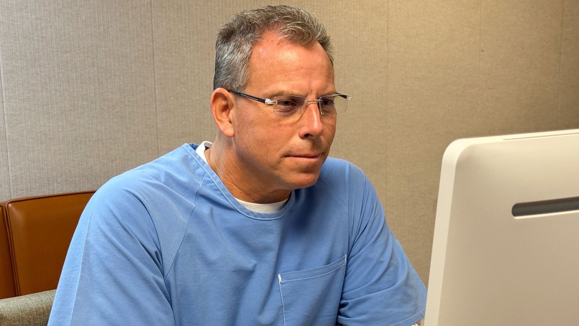 erik menendez sitting in front of computer 