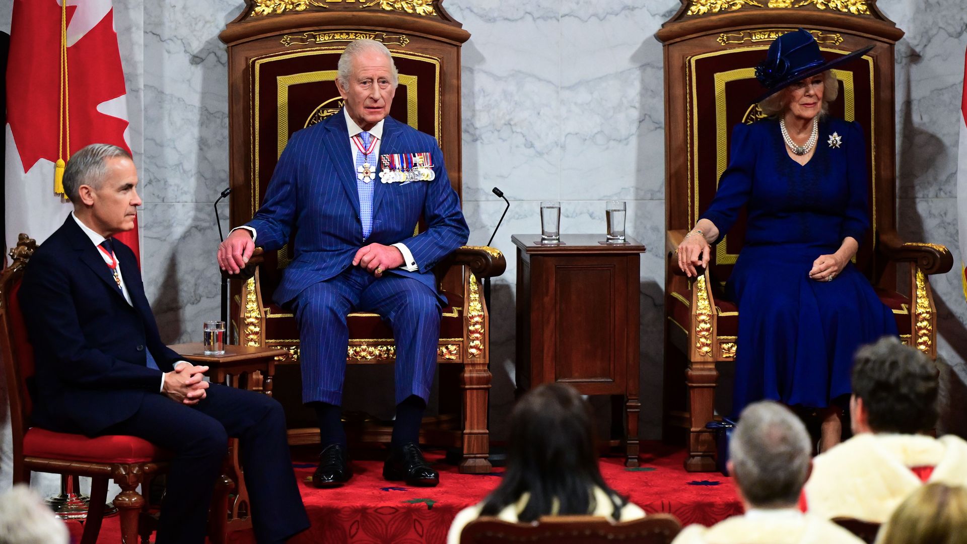 King Charles and Queen Camilla sitting on a pair of thrones