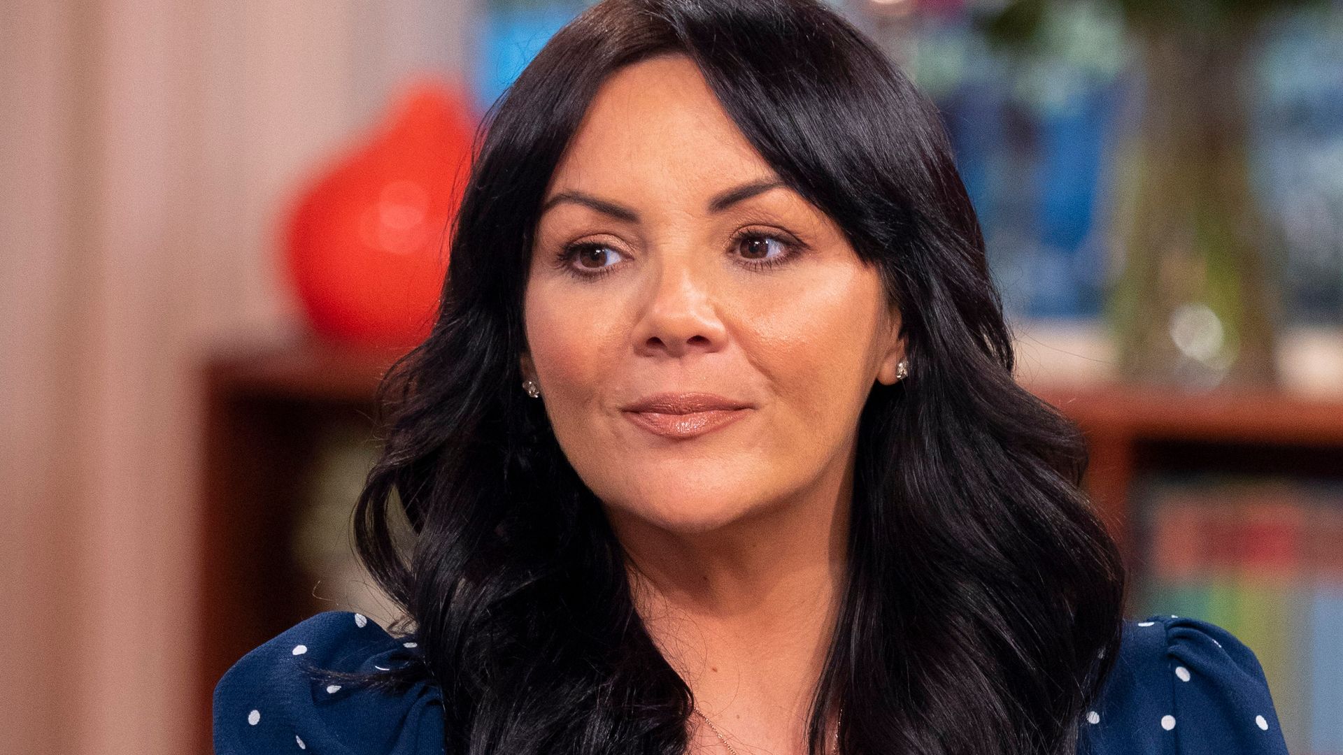 Martine McCutcheon in a blue spotty top on the sofa