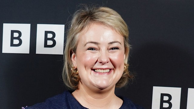 Philippa Dunne smiling in a blue dress covered in hearts