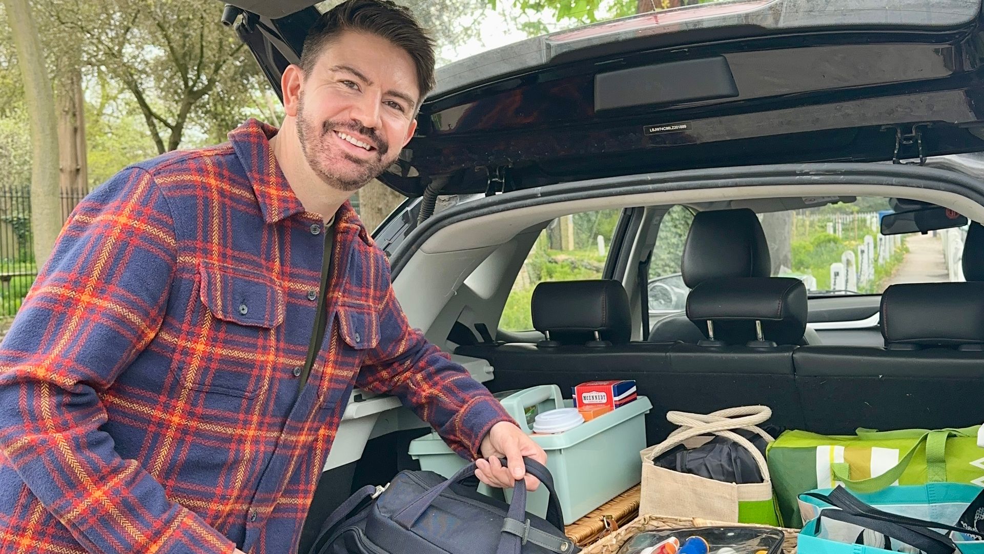Iwan Carrington from Sort Your Life Out holding onto bags in a packed car boot