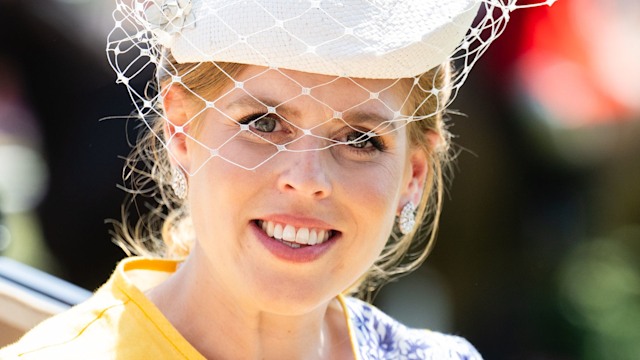 Princess Beatrice smiling in yellow dress and net hat