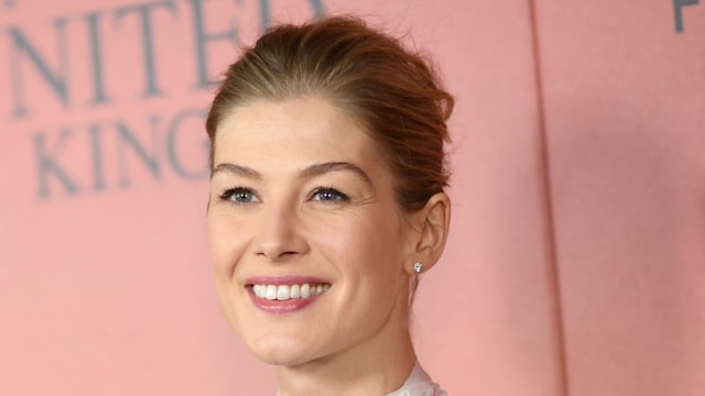 Rosamund Pike smiling in a white dress