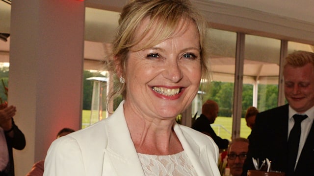 Carol Kirkwood in a white lace dress at a dinner party