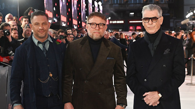 Tom Hardy standing with Guy Ritchie and Pierce Brosnan
