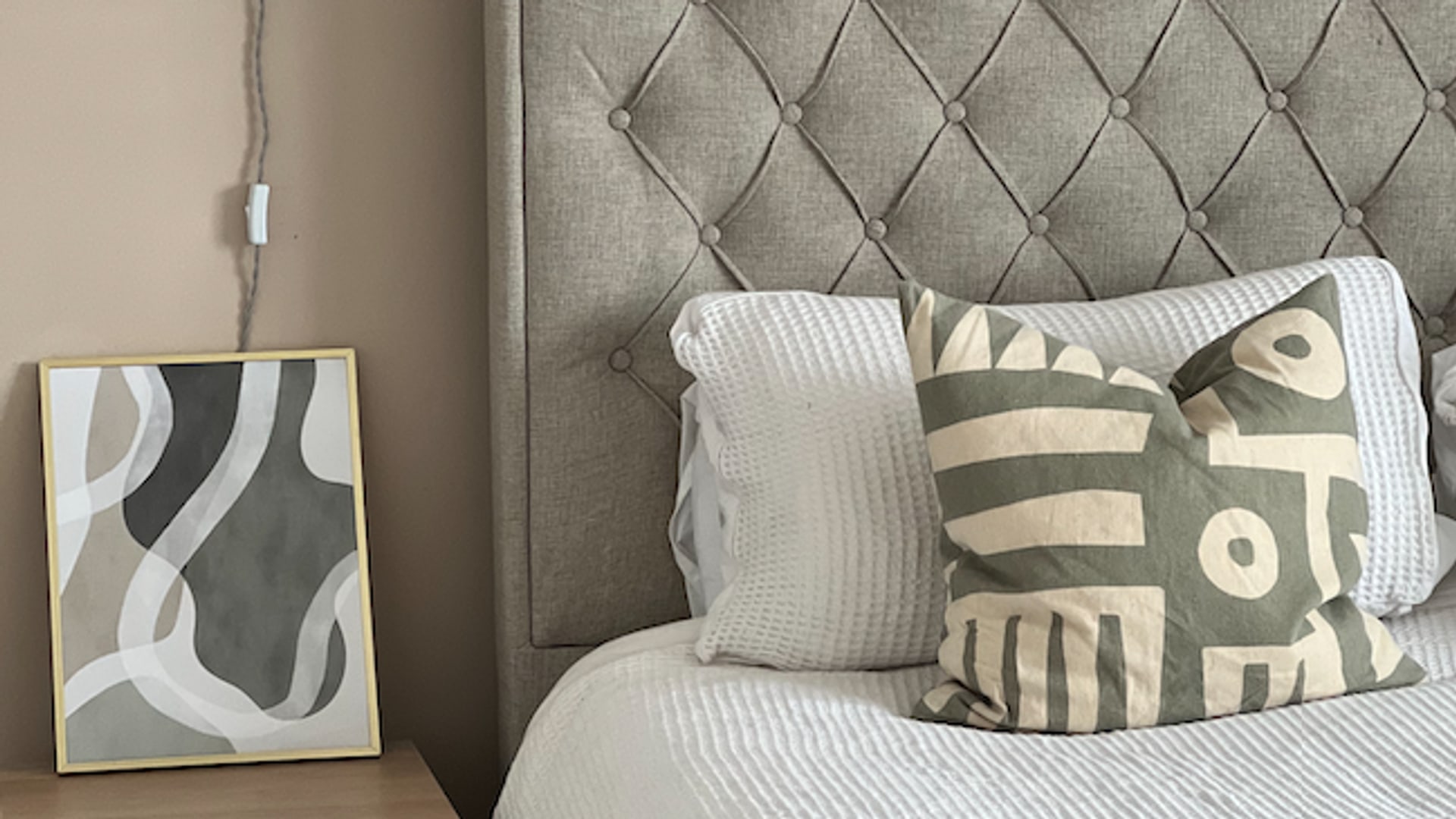 bed with large headboard with bedside cabinet, light and picture frame