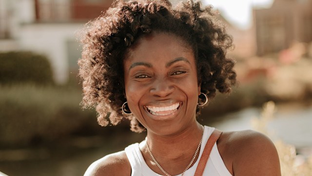 Woman smiling in a white vest