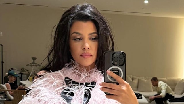 Kourtney Kardashian poses in front of a mirror 