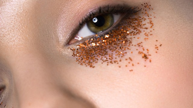 Close-up of beautiful woman with creative festival glitter make-up