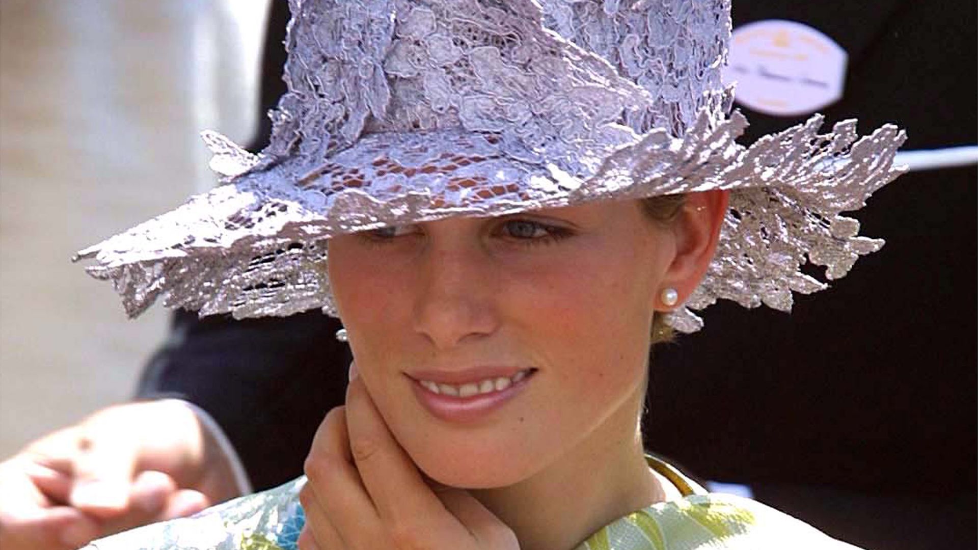 Zara Tindall wears a lace hat , pearl earrings and cowl-neck green dress