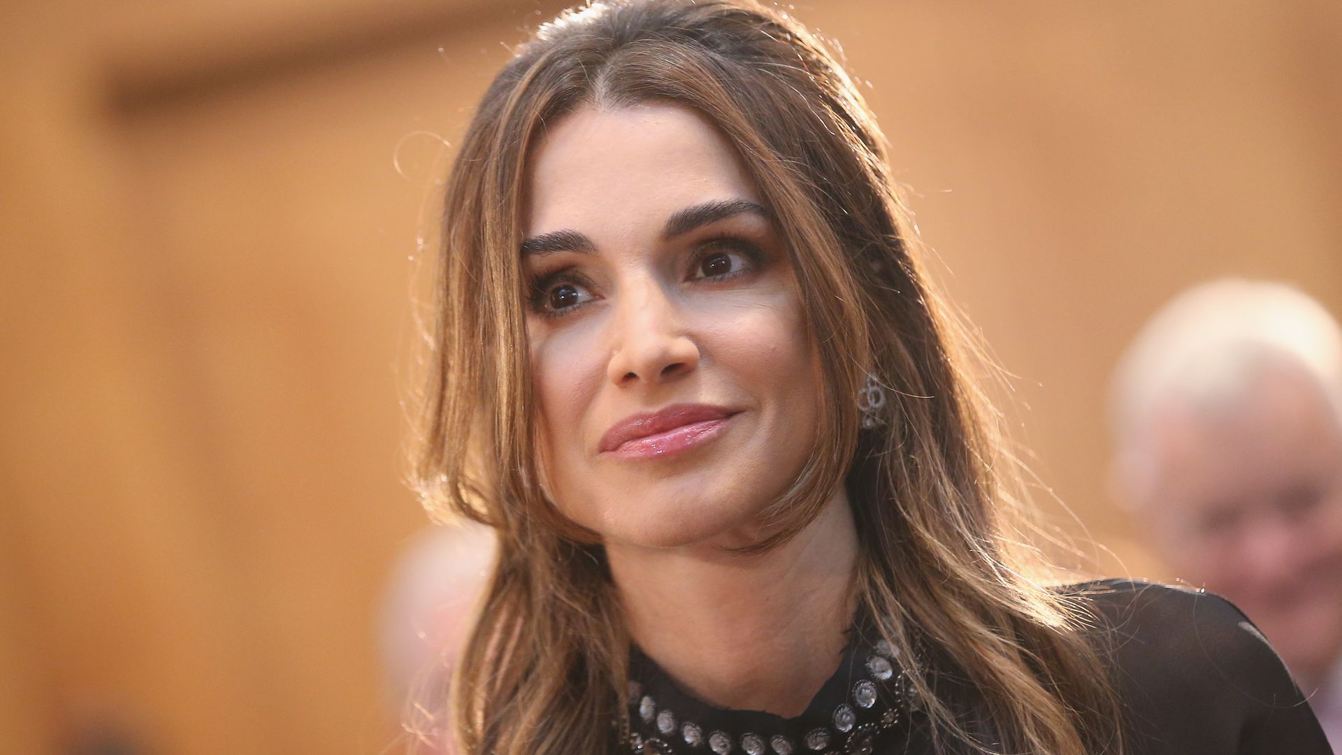 Queen Rania of Jordan in a black dress with curled hair