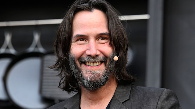 Keanu Reeves smiling on stage