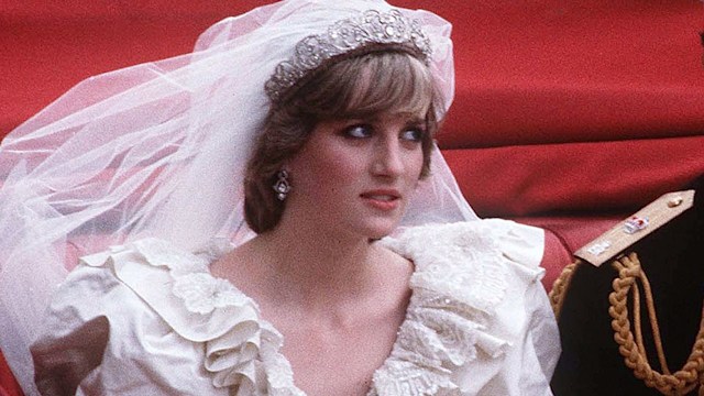 Prince Charles and Princess Diana ride in an open carriage from St. Paul's Cathedral to Buckingham Palace following their wedding