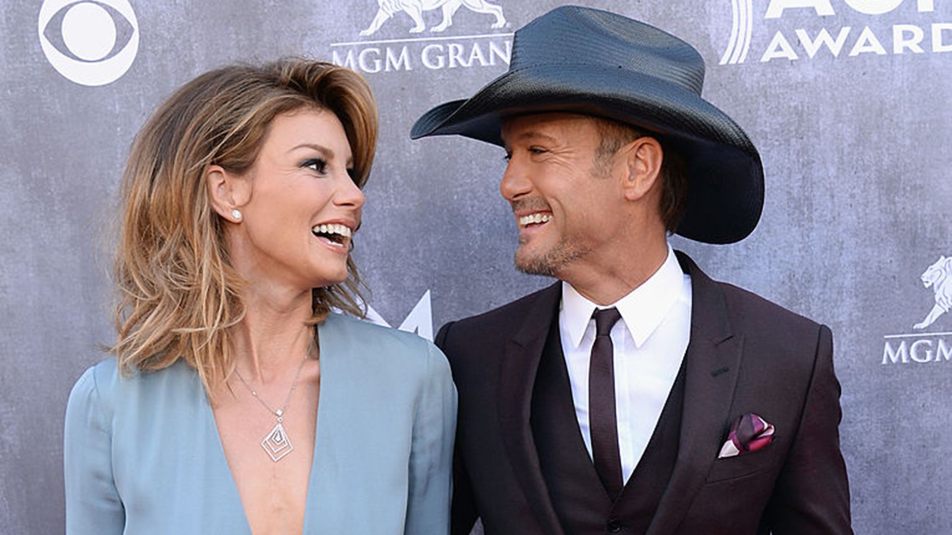 Tim McGraw and Faith Hill smile at one another during 49th Annual Academy Of Country Music Awards red carpet