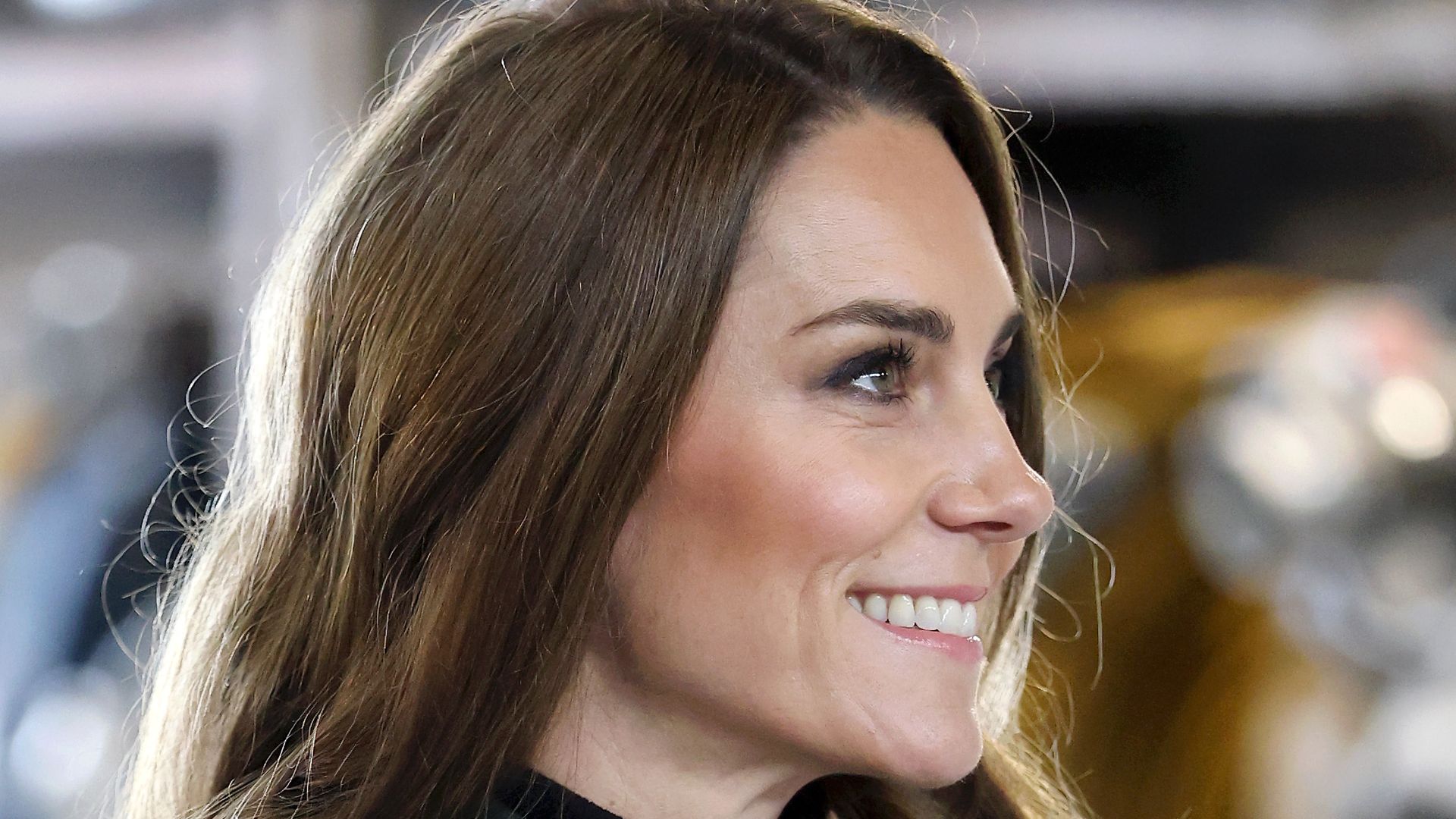 Catherine, Princess of Wales side on in dark green coat dress