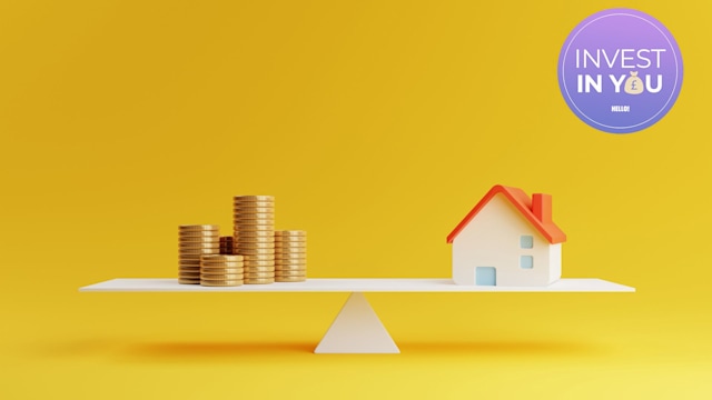 Coins and a house on a scale against a yellow background