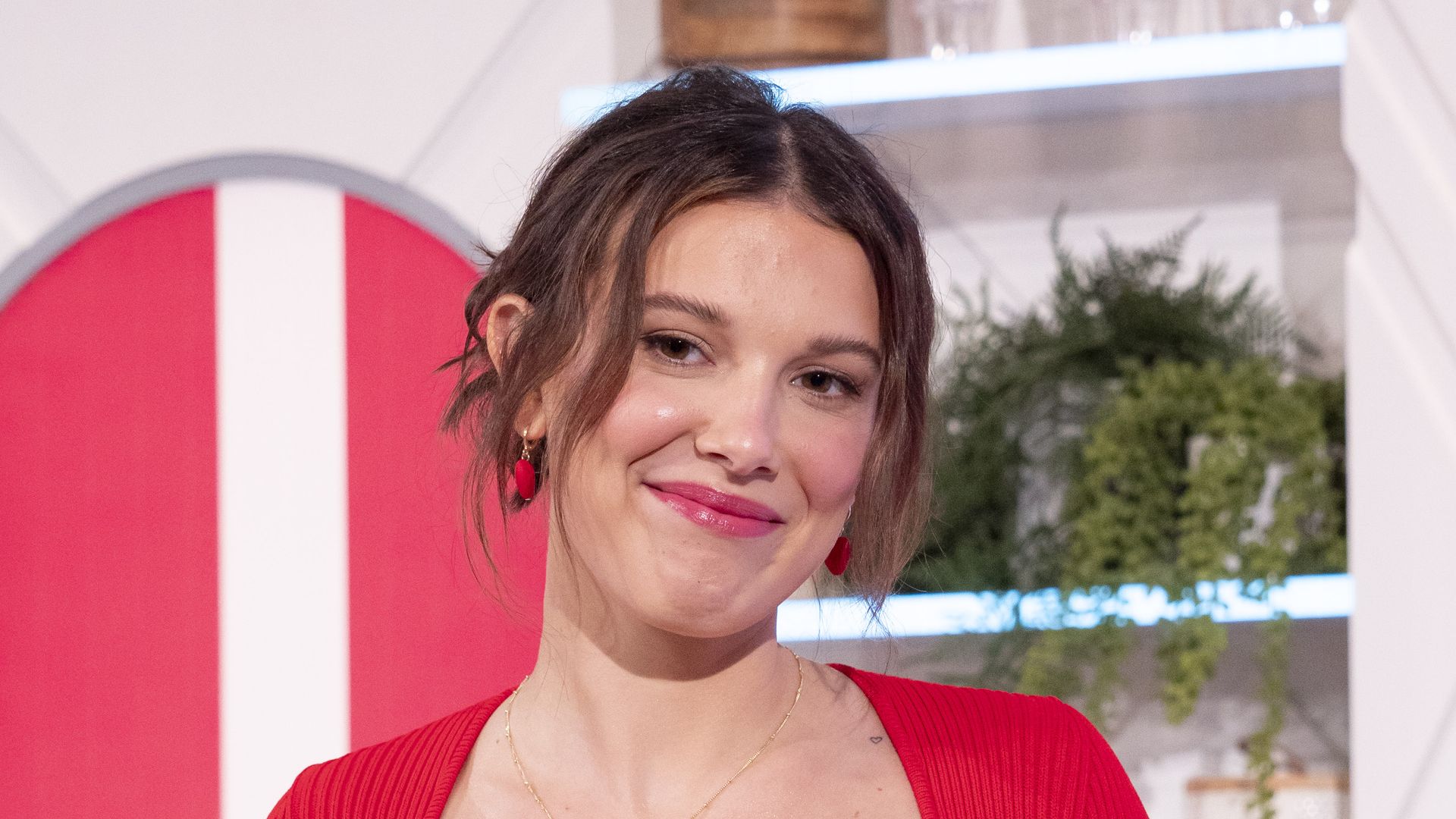 Millie Bobby Brown in a red dress on TV