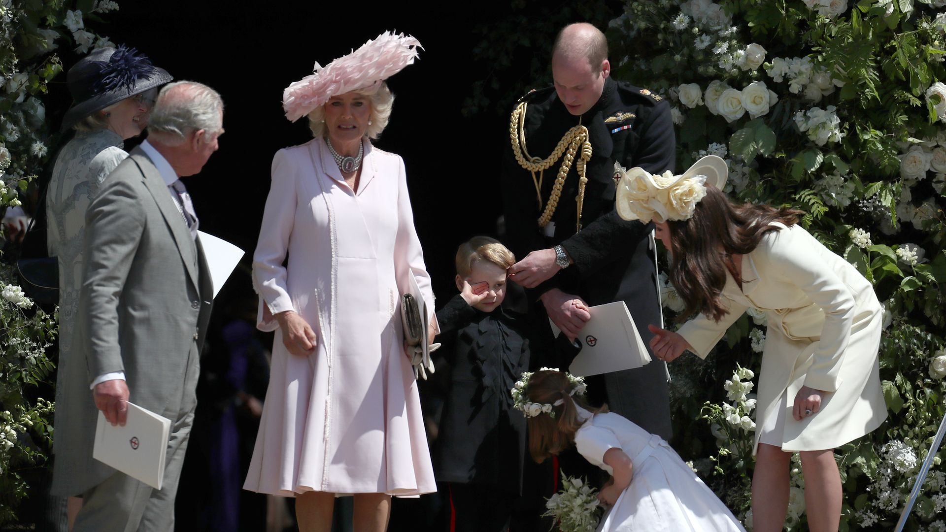 King Charles and Queen Camilla at a wedding as Prince George wipes his eye by Princess Charlotte