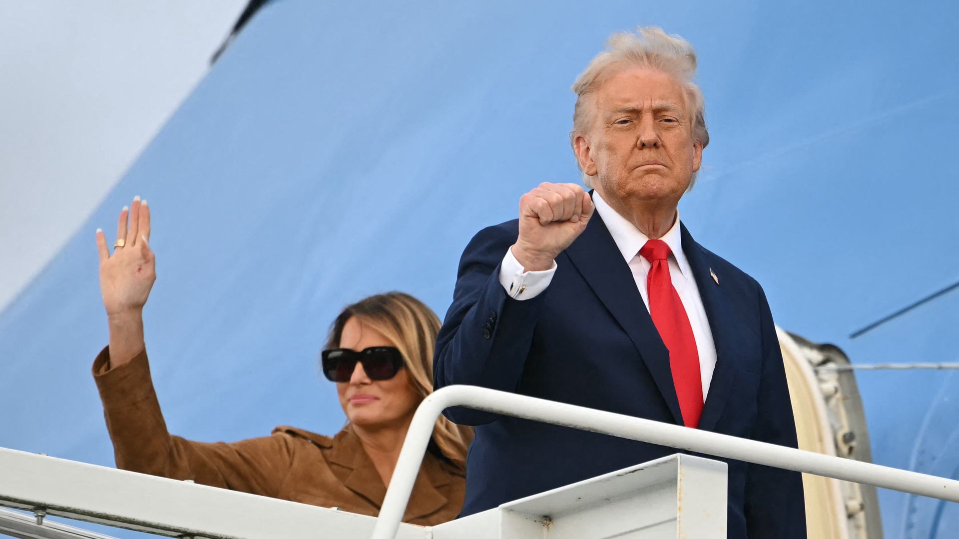 Donald Trump (R) gestures as he and US First Lady Melania Trump (L) board Air Force One at Stansted Airport, in Stansted, north of London, on September 18, 2025, to leave at the end of the US President's second State Visit