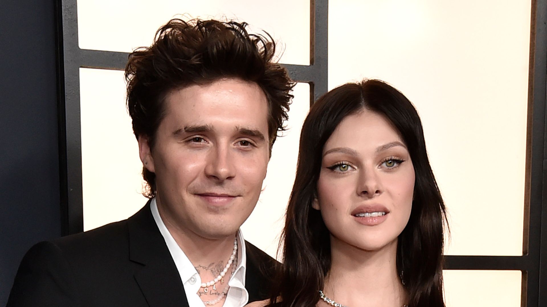 Brooklyn Beckham and Nicola Peltz in white dress on red carpet