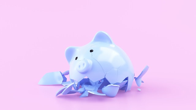 Blue ceramic piggy bank broken, on pink background