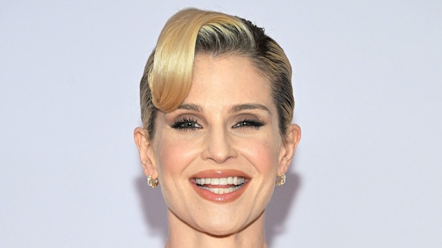 Kelly Osbourne smiling in black gown shoulders up