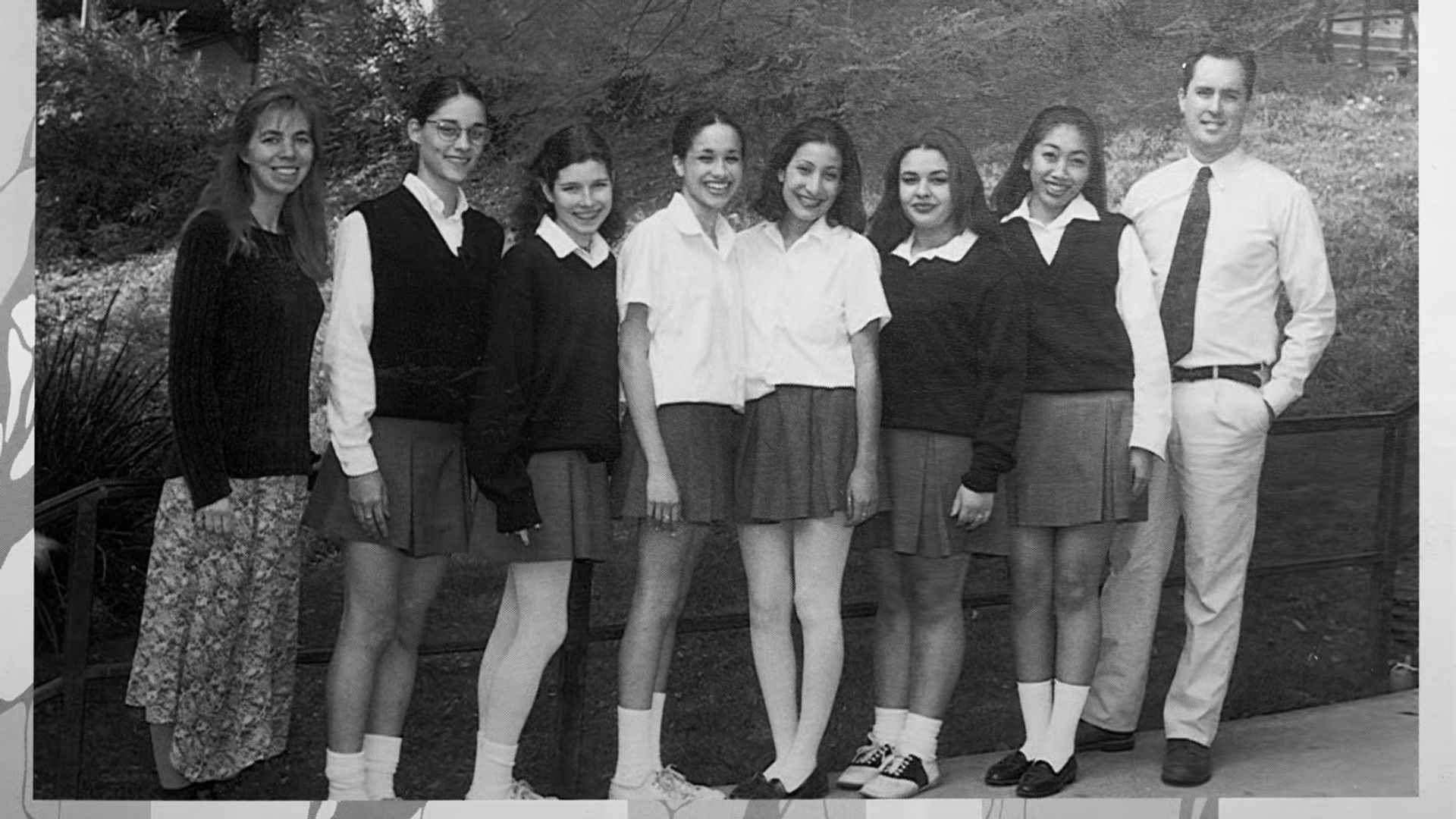 Meghan Markle yearbook photo, she stands in the middle in a white shirt and skirt