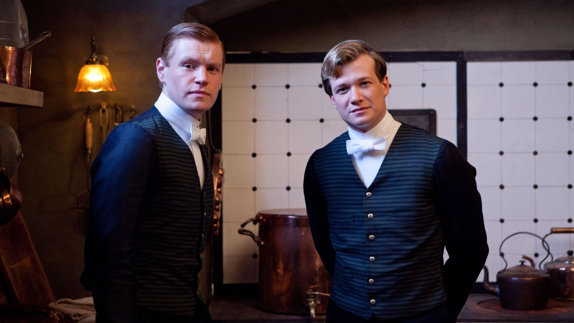 Two men in period clothing in kitchen