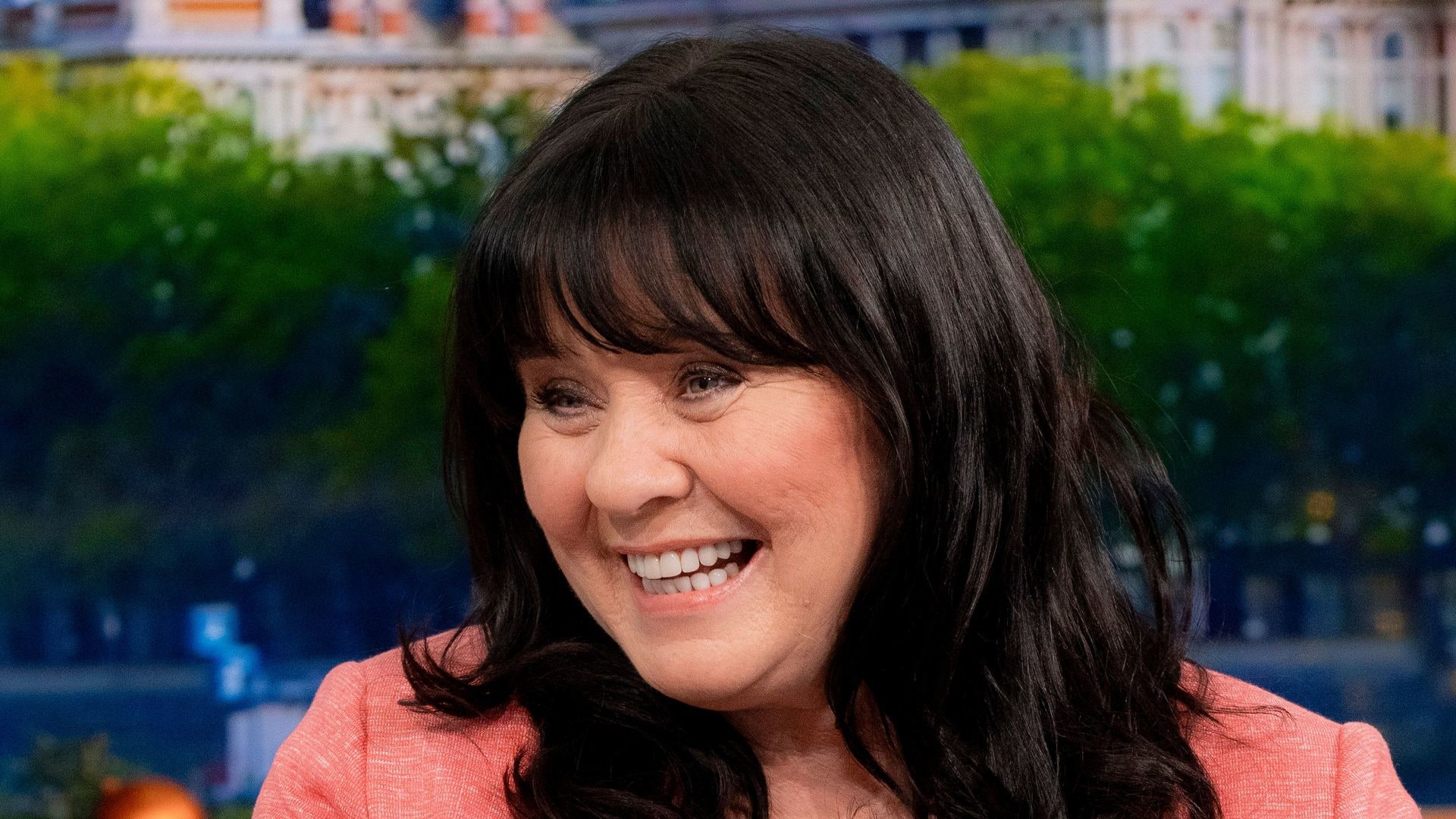 Coleen Nolan smiling in a peach jacket