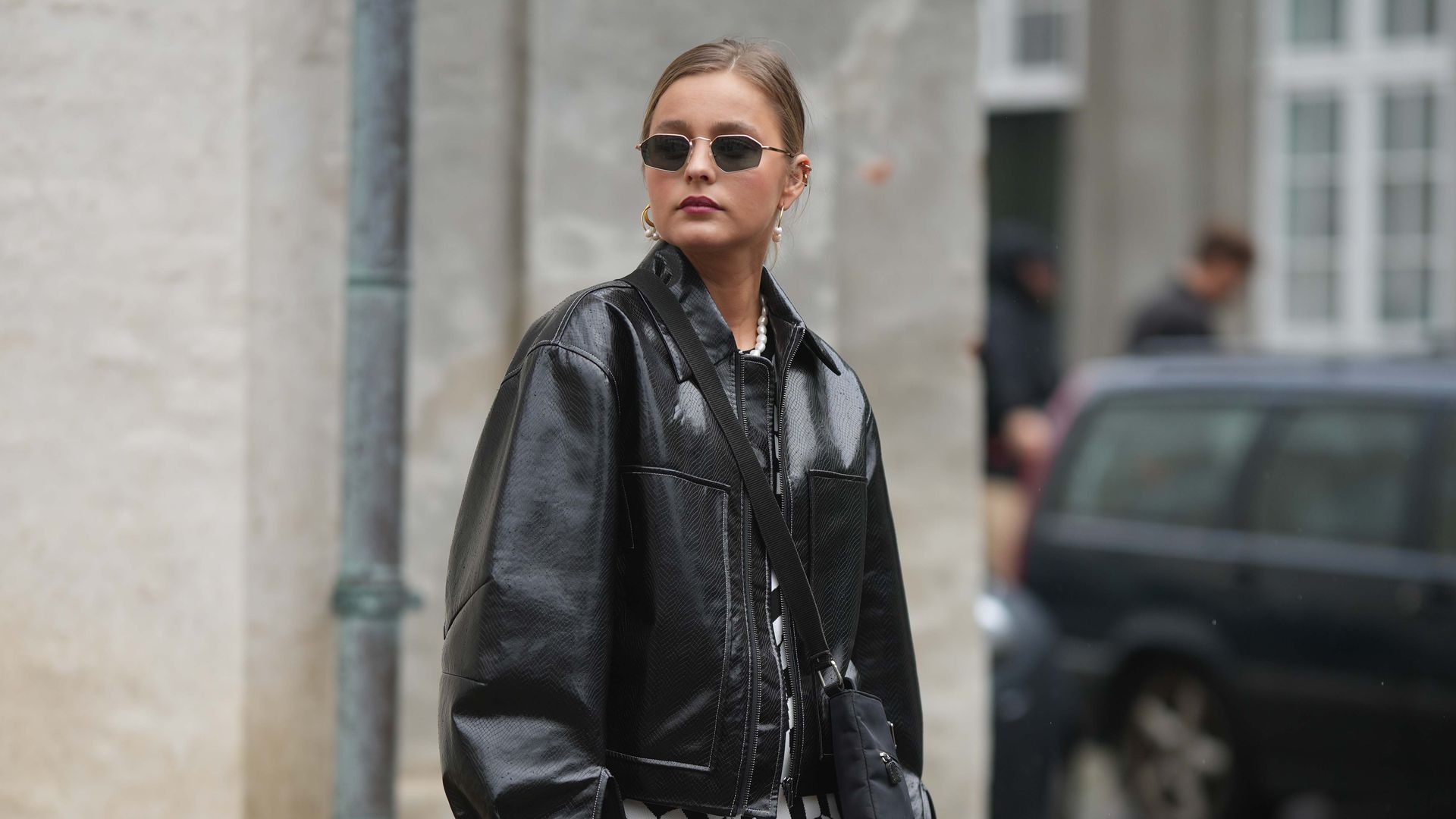 Fashion week guest wearing leather bomber jacket with geometric midaxi 