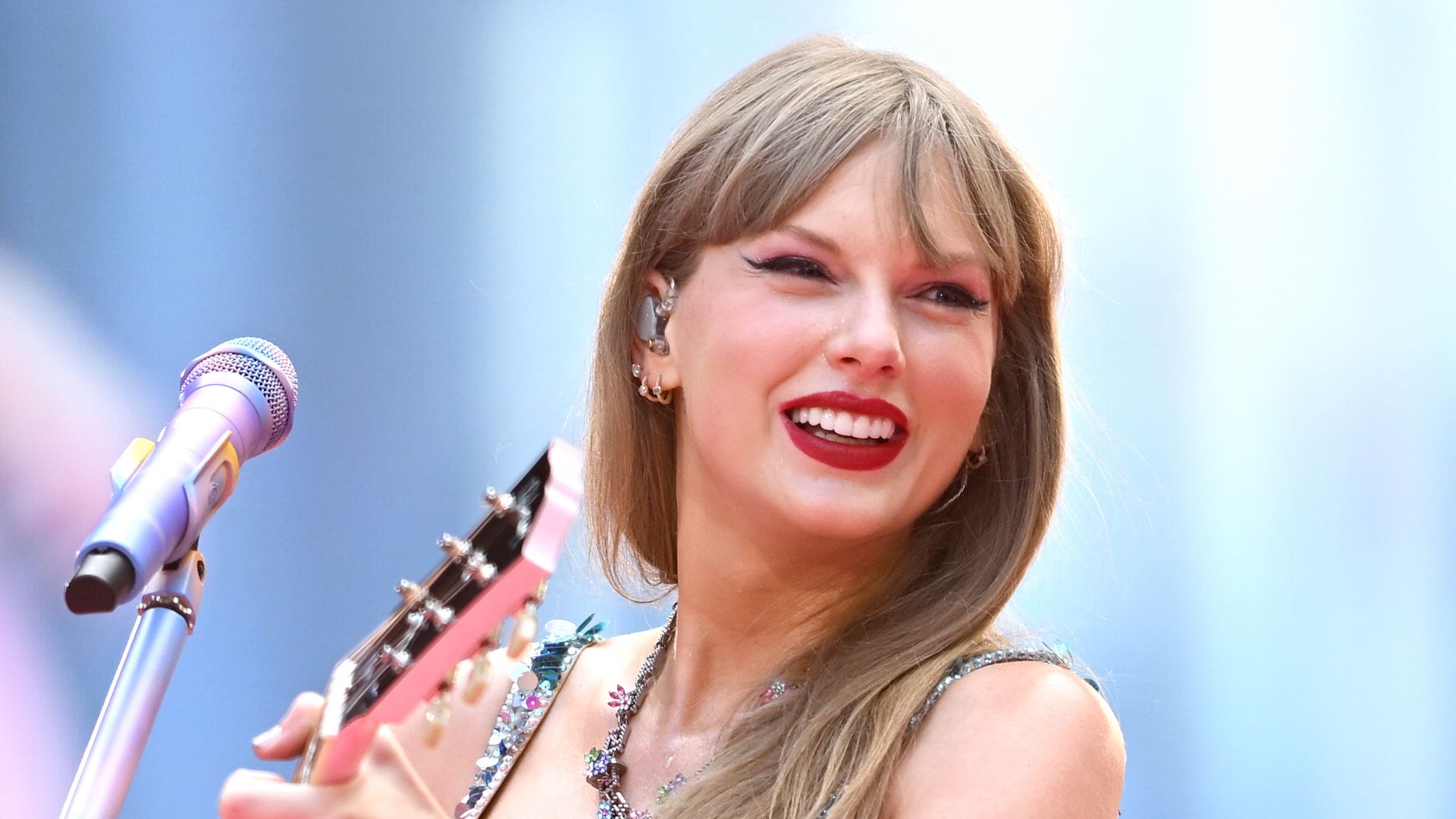 Taylor Swift performs on stage in pastel bodysuit