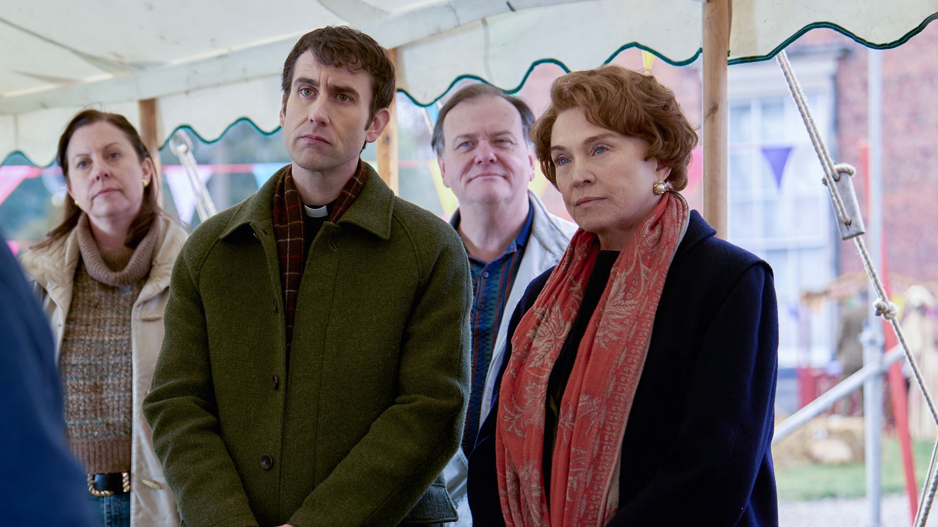 man and woman standing outdoors under white tent