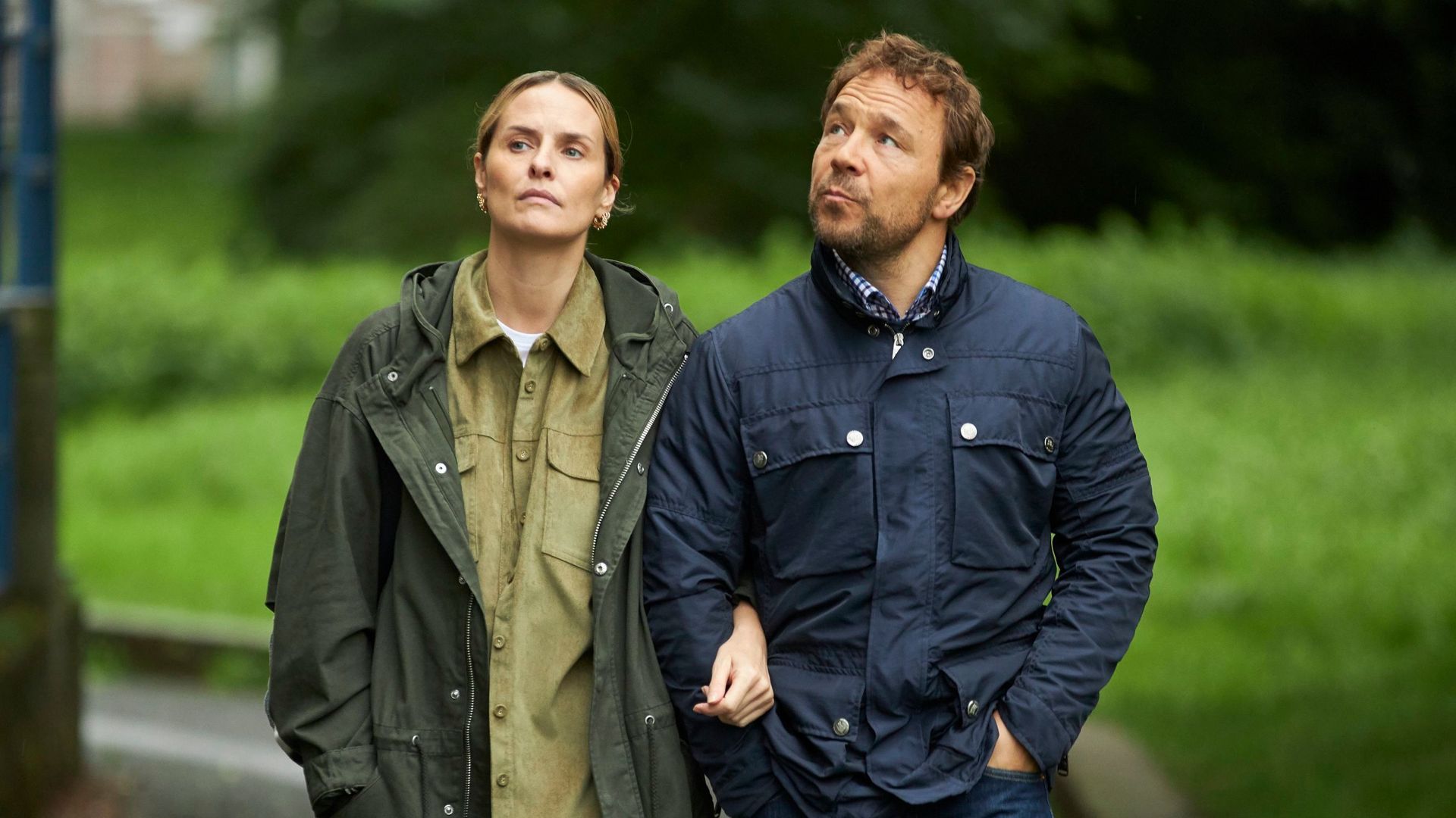 woman and man walking outdoors linking arms