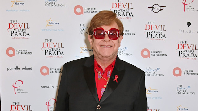 Sir Elton John poses in red glasses