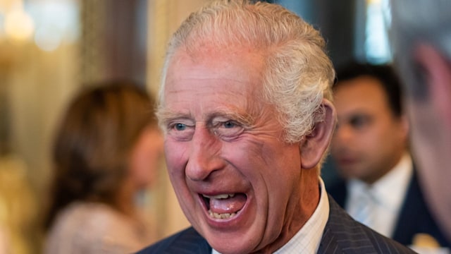 King Charles laughing inside Buckingham Palace