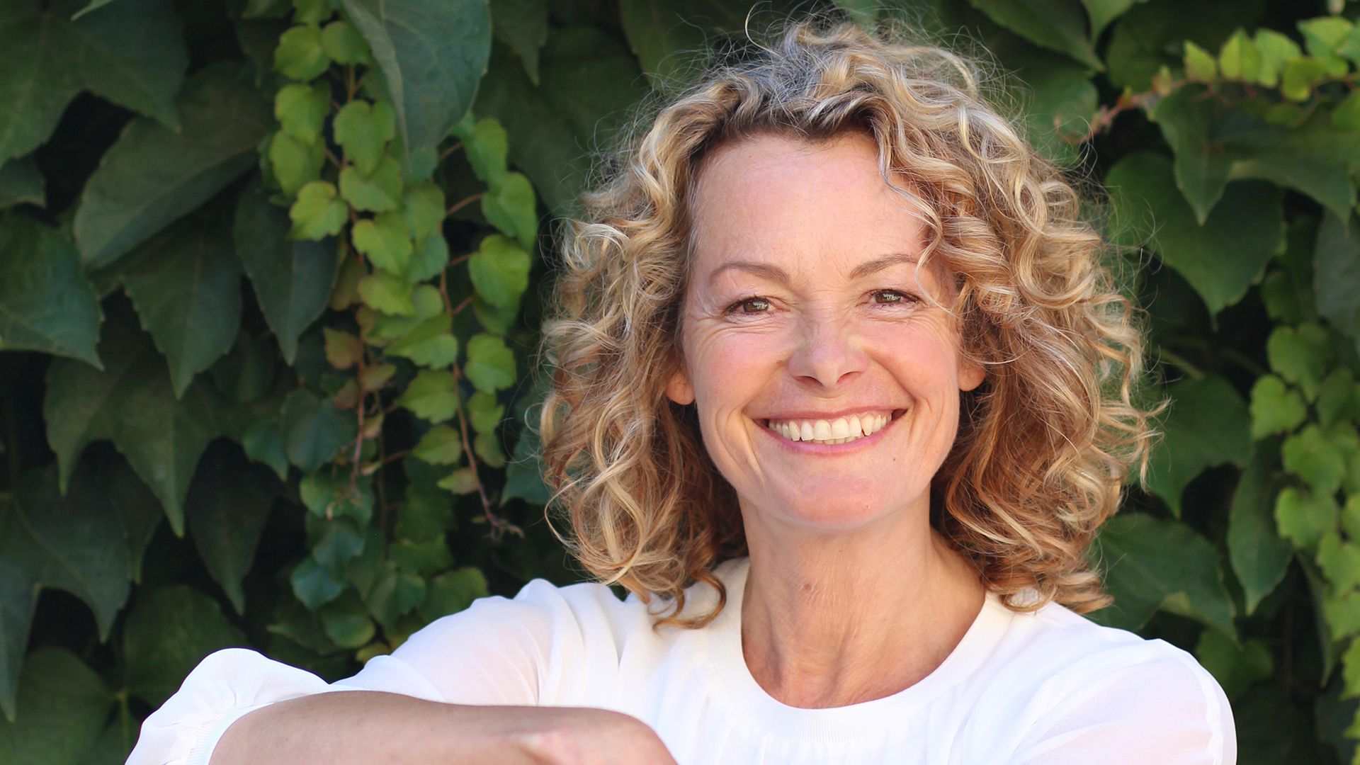 Kate Humble smiling in a garden. 