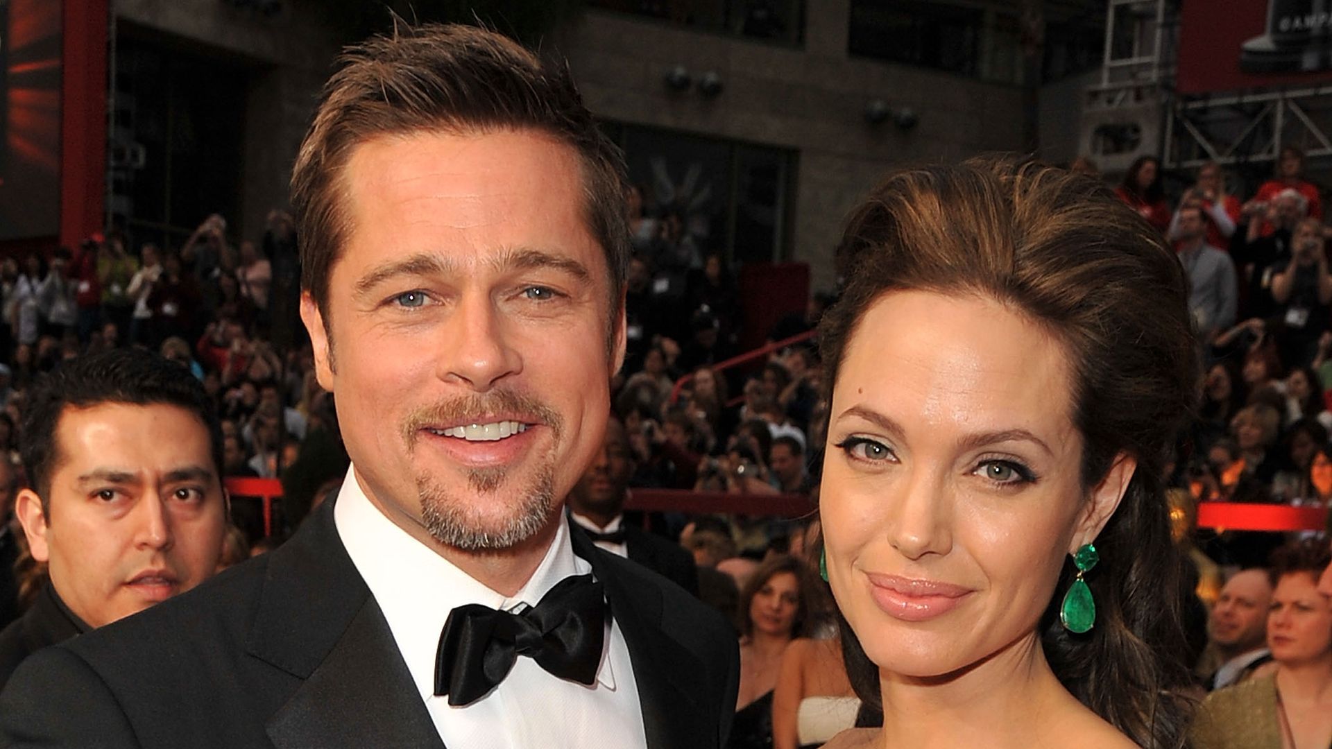 Brad Pitt and Angelina Jolie with their arms around eachother smiling