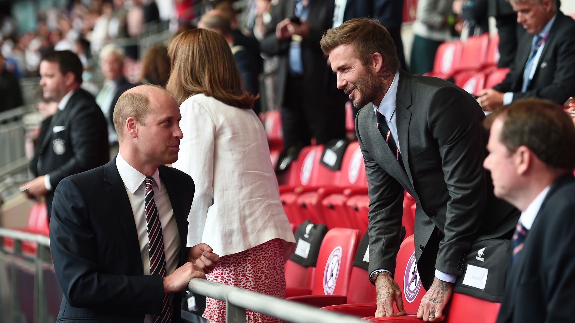 Prince William talking to David Beckham at a football match