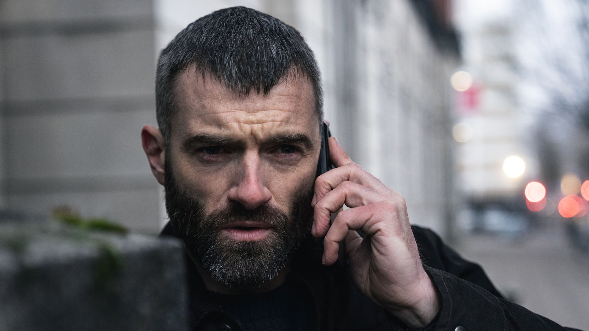 close-up of man holding phone in street