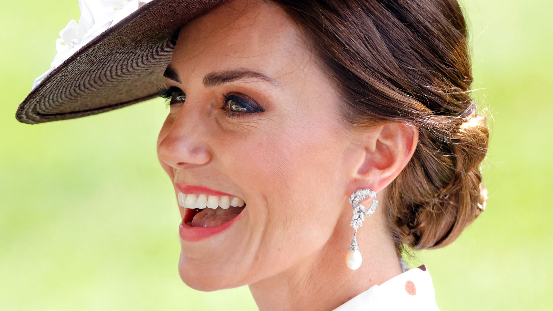 princess kate wearing a bun hairstyle, hat and earrings