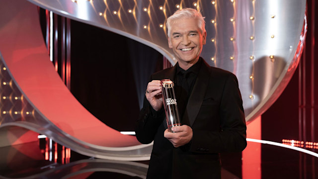 Phillip Schofield holding one of the covered British Soap Awards