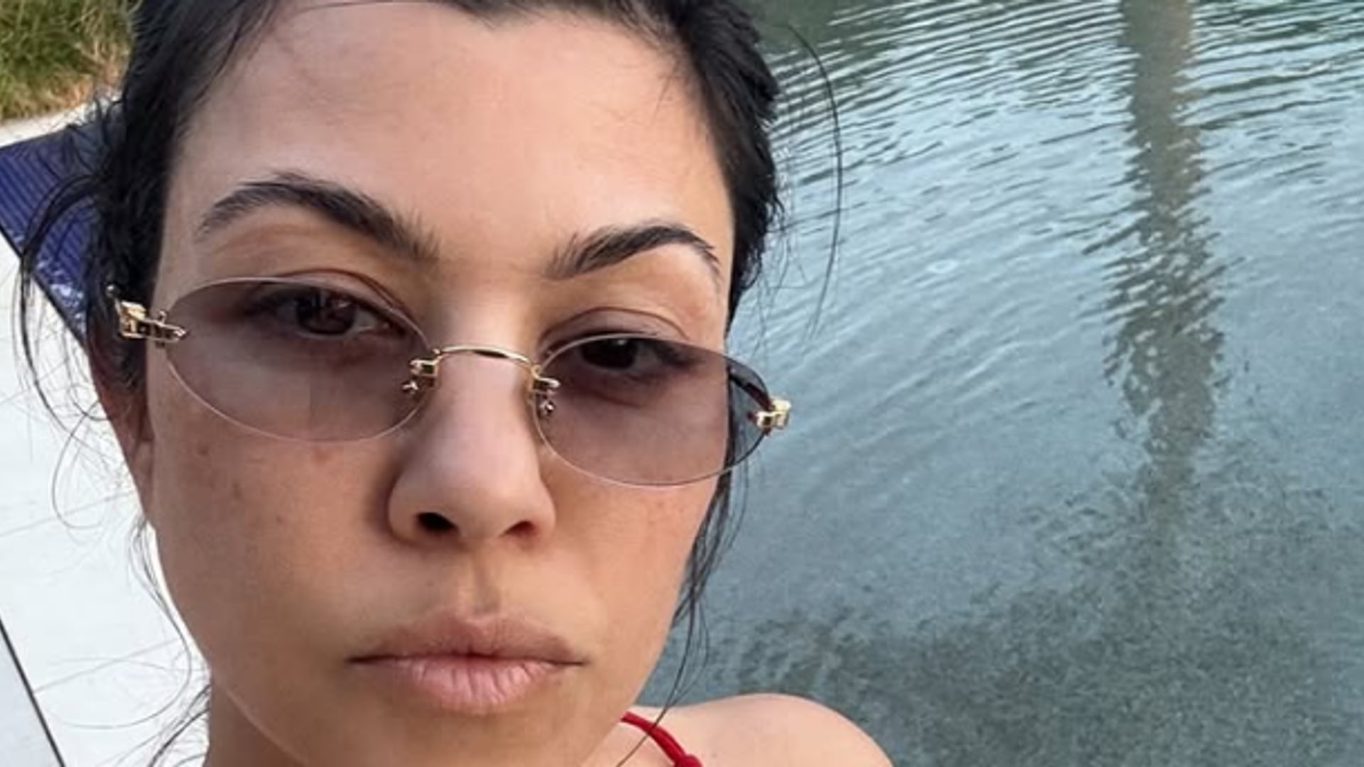 Kourtney Kardashian taking a selfie in front of her pool at Palm Springs home