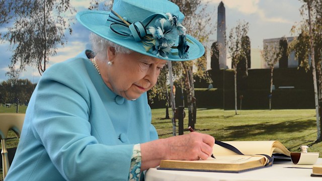 Queen Elizabeth writing in a book