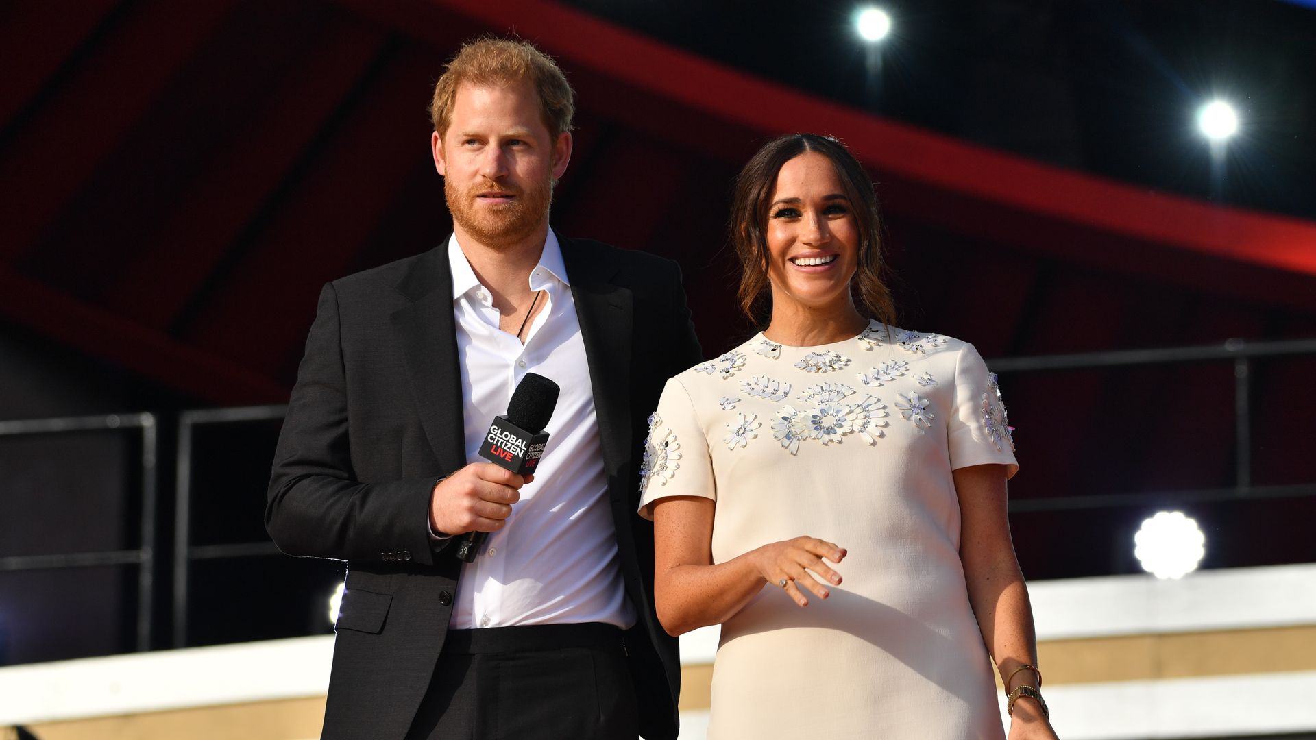 Meghan Markle and Prince Harry holding microphones