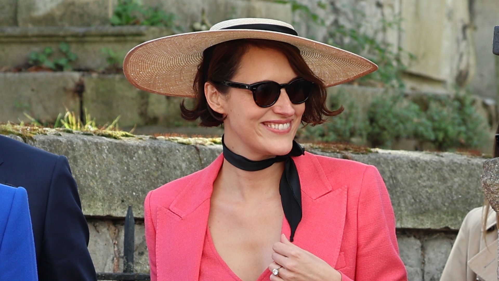 Phoebe Waller-Bridge wears a coral suit and boater hat
