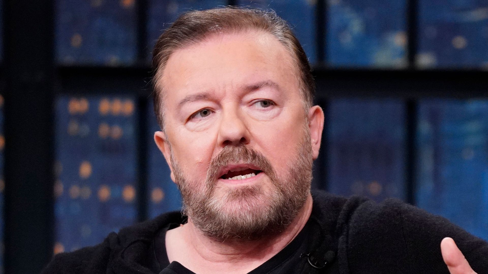 Actor/comedian Ricky Gervais during an interview with host Seth Meyers in black hoodie