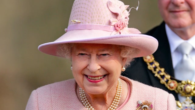 Queen Elizabeth II carries a posy of flowers as she leaves Manchester Town Hall after a visit as part of her Diamond Jubilee Tour of the UK on March 23, 2012 in Manchester, England. 