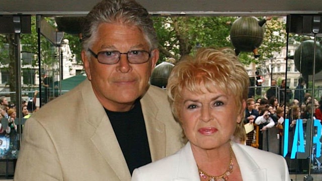 Gloria Hunniford in a white and red suit with her husband Stephen Way in a cream suit